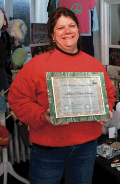 Female award recipient with certificate and red sweatshirt